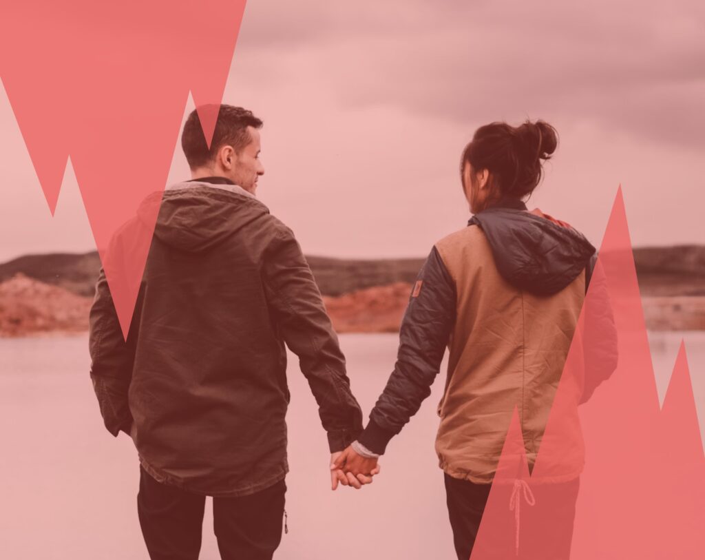 Un couple marche main dans la main face à un paysage calme, symbole d’une relation passée à analyser pour avancer quand on fait son bilan de fin d'année