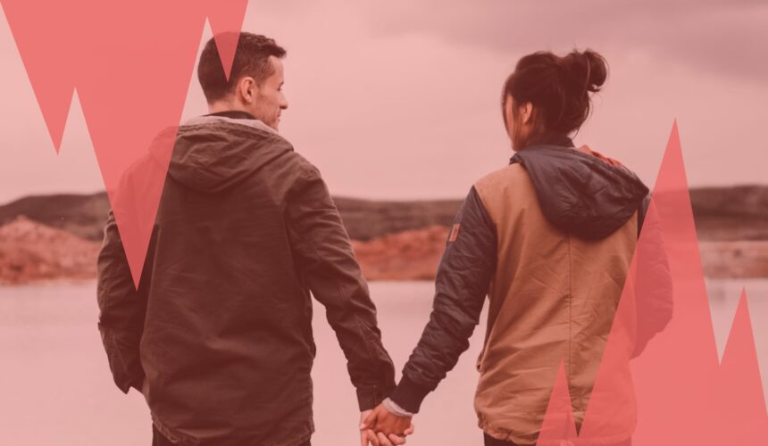 Un couple marche main dans la main face à un paysage calme, symbole d’une relation passée à analyser pour avancer quand on fait son bilan de fin d'année