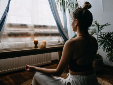 Une femme pratique la méditation vipassana devant une fenêtre