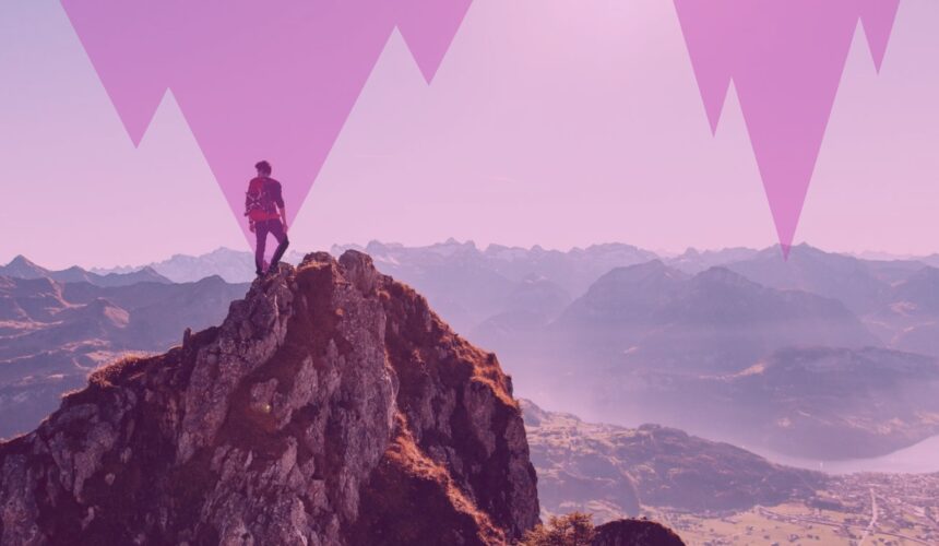 Personne debout au sommet d'une montagne contemplant un vaste paysage naturel, symbolisant la congruence, l'accomplissement personnel, la sérénité et l'harmonie intérieure.