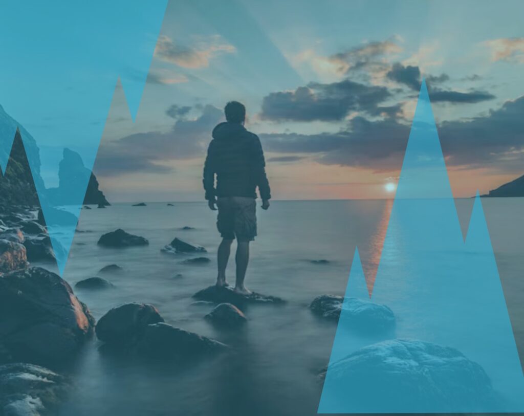 Homme seul face à la mer au coucher du soleil, symbole de rupture amoureuse et du fait de toujours penser à ton ex