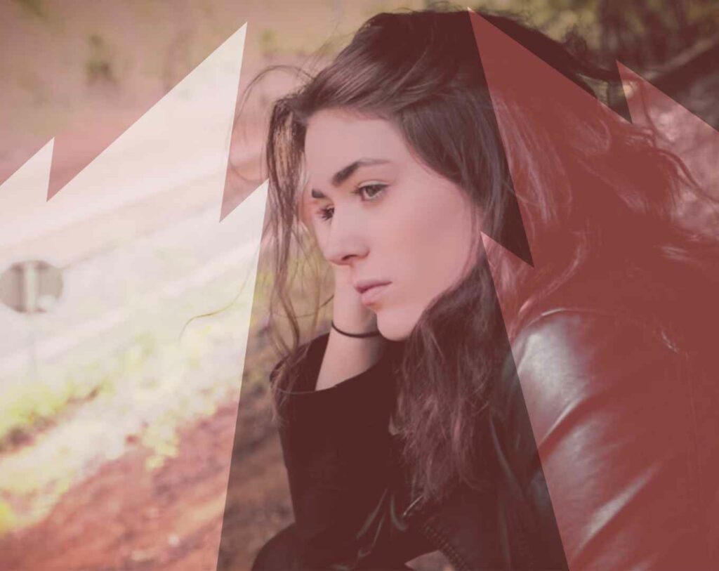 Femme qui se tient la tête dans la main, avec le fantôme de son ex derrière elle, illustrant le fait de toujours penser à son ex et la difficulté de tourner la page.