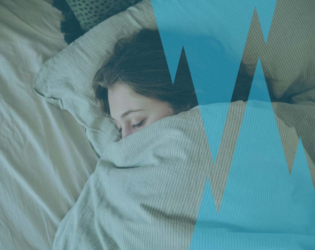 Femme allongée dans son lit qui pense encore à son ex, symbole de la difficulté à tourner la page après une rupture