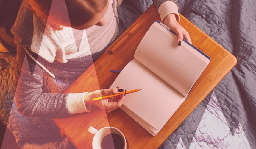Femme écrivant dans un carnet avec une tasse de café, pratique de journaling introspectif à la maison
